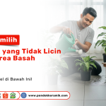Tips Memilih Keramik yang Tidak Licin untuk Area Basah. Seorang pria menyiram tanaman di dalam ruangan dengan lantai keramik yang tidak licin.