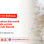 Seorang pria sedang mengecek tekstur keramik abu-abu di dinding display sebagai visual cara memilih keramik untuk teras yang kuat dan tidak mudah kotor