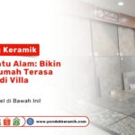 Seorang staf pria di toko bangunan sedang menunjukkan display keramik dinding dan lantai motif batu alam yang beragam